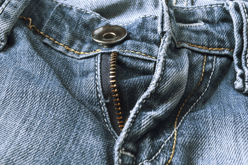 Take a key ring about the size of a penny. Loop it through your zipper, and zip up your pants. Then attach the key ring to your top button.